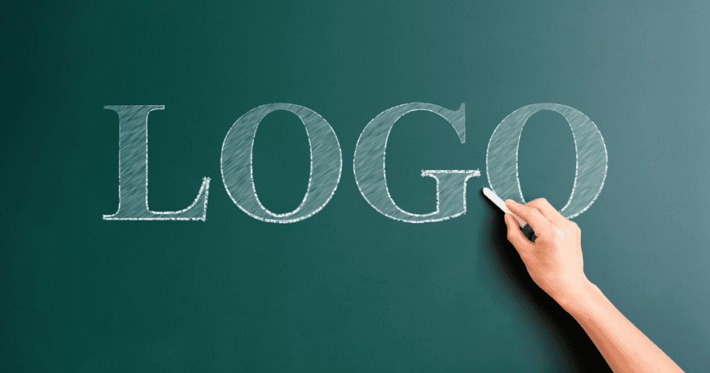 Hand writing "logo" in white chalk on a green chalkboard