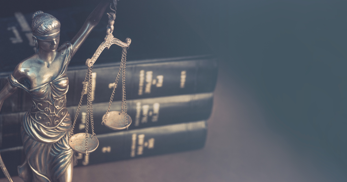 Photo in front of a statue of lady justice with her scales and text books to illustrate the tax ramifications of not paying attention to proper font licensing.